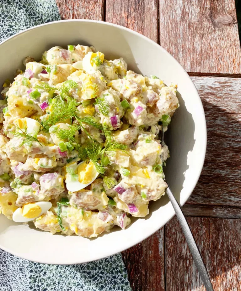 Printed Dijon potato salad recipe next to serving bowl
